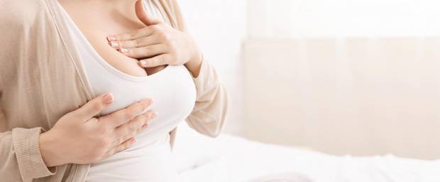 Schwangere Frau berührt Ihre Brust